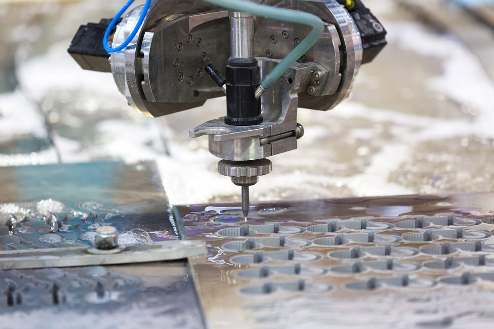 a waterjet cuts intricate shapes into steel material